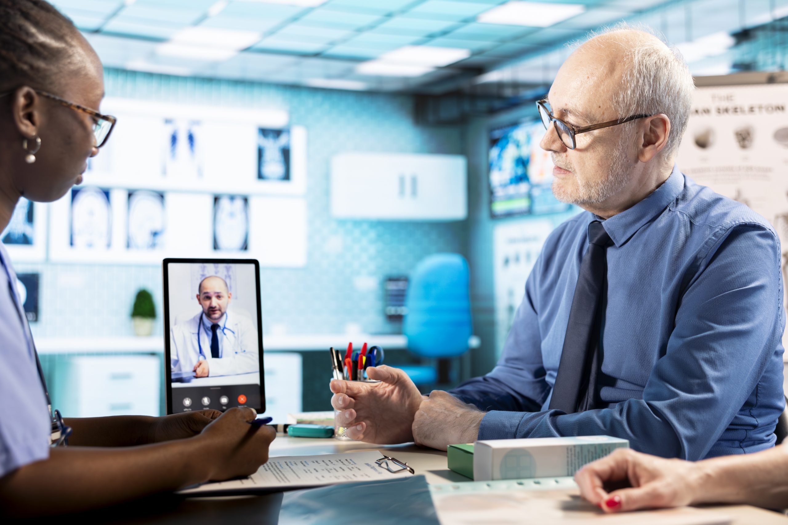 nurse consulting her patients while being on videocall with physician